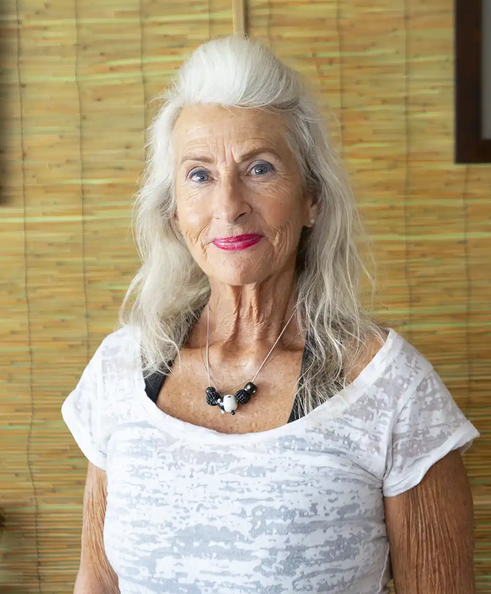 woman smiling next to bamboo wall massage therapy in key west in acupuncture office