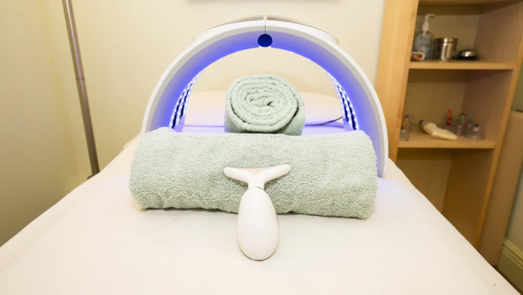 infrared light therapy device glowing blow over a massage table and towels in massage office in key west